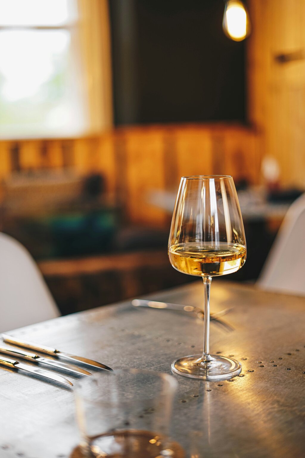 Glas mit Weißwein. Steiermarkt, natürlich kostbar. Ilse Stachel. Bild von Rick Barret über Unsplash.